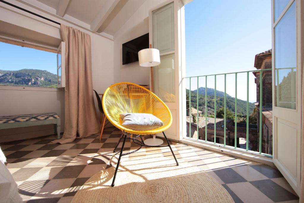 a yellow chair sitting in a room with a balcony at Ca's Papà in Valldemossa