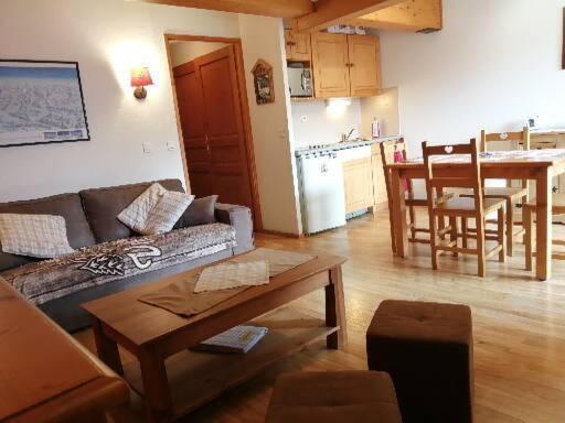 un soggiorno con divano e tavolo e una cucina di Appartement Valmeinier 4 à 5 personnes Résidence LAGRANGE a Valmeinier