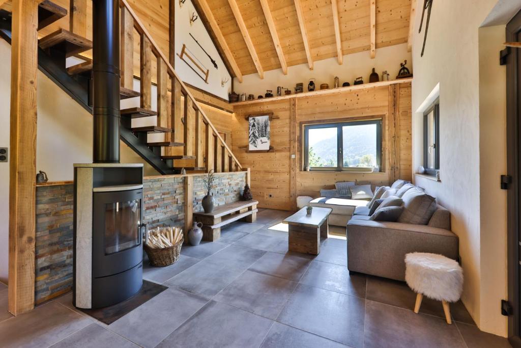 a living room with a couch and a fireplace at Chalet Rothenbach in Mittlach