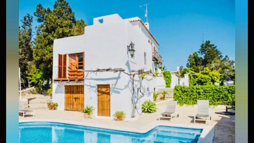 a house with a pool in front of it at Sera de Vall in San Antonio Bay