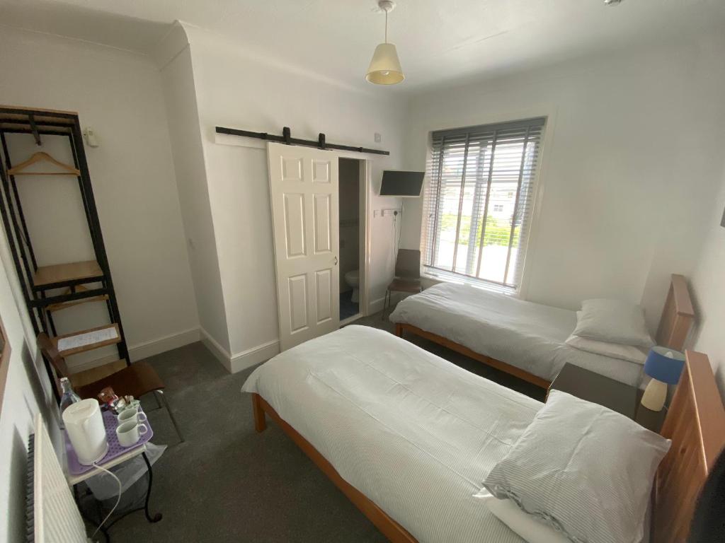 a bedroom with two beds and a window at The Sandhaven in Swanage