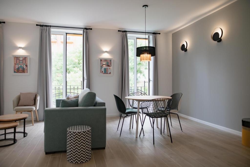 ein Wohnzimmer mit einem Sofa, einem Tisch und Stühlen in der Unterkunft Apartamentos Líbere Valencia Abastos in Valencia