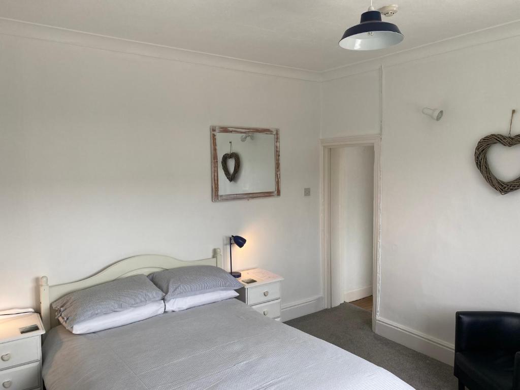 a bedroom with a bed and a table and a mirror at The Sandhaven in Swanage