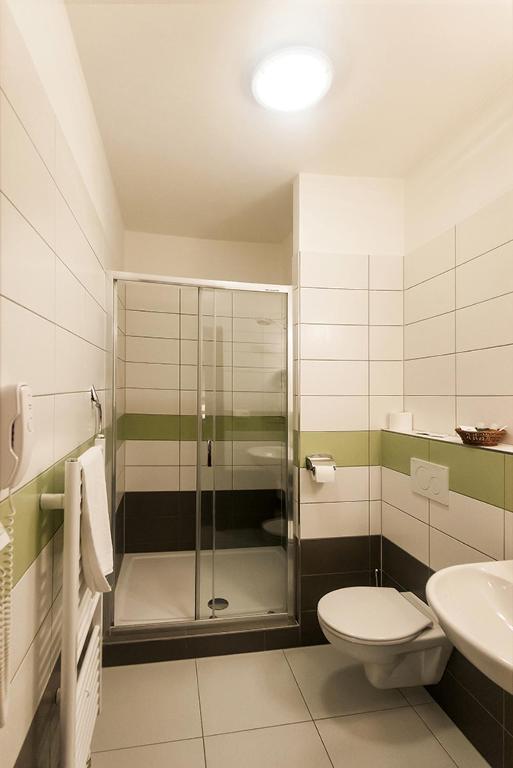 a bathroom with a shower and a toilet and a sink at Arkada Hotel in Bučovice