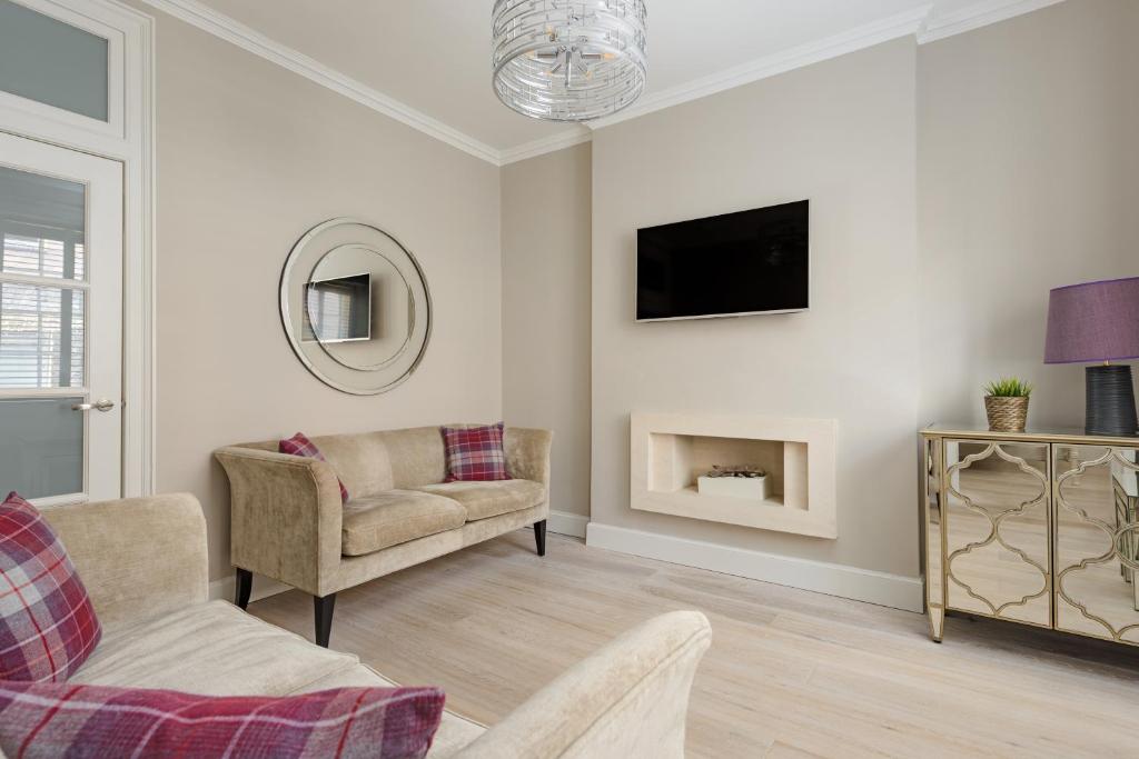エディンバラにあるThe Rose Street Apartmentのソファと壁掛けテレビのあるリビングルーム