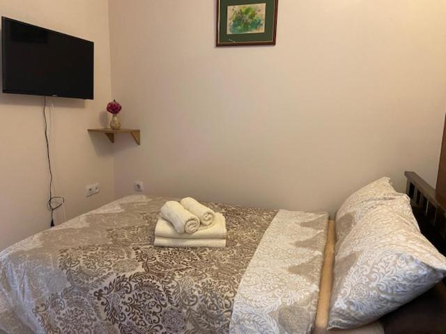 a bedroom with a bed with two towels on it at Lux Apartment Kotez in Pančevo