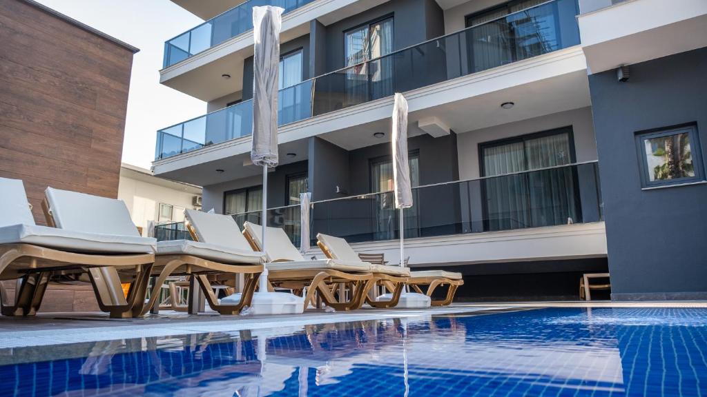 a swimming pool with lounge chairs and a hotel at Nas Suite in Alanya