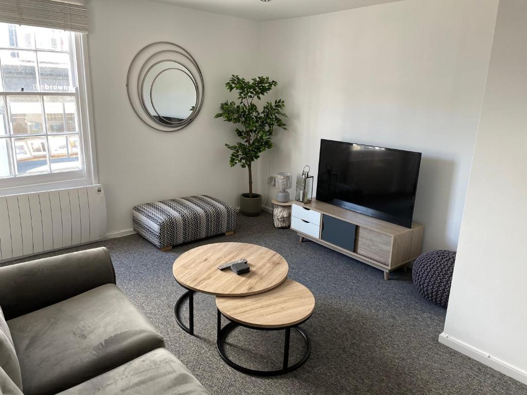 sala de estar con sofá y mesa en Brownston Apartments en Modbury
