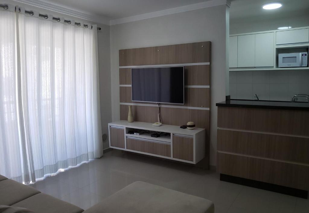 a living room with a flat screen tv on a wall at Excelente apto 3 quartos em Bombas, 100 metros do mar e 2 vagas de garagem in Bombinhas