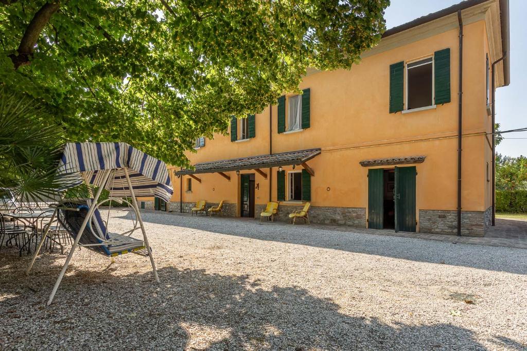 um edifício com uma cadeira em frente em Podere con piscina sulle colline di Rimini em Rimini