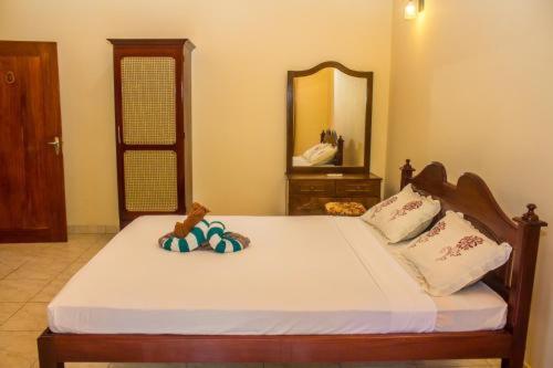 a bedroom with a large bed with a mirror at Sakura Villa Bentota in Bentota