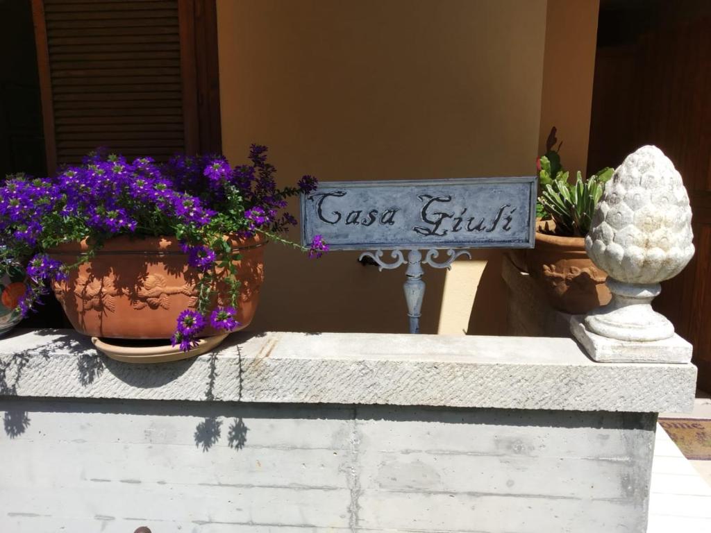 a sign on a wall with some plants and flowers at Casa Giuli in Manerba del Garda