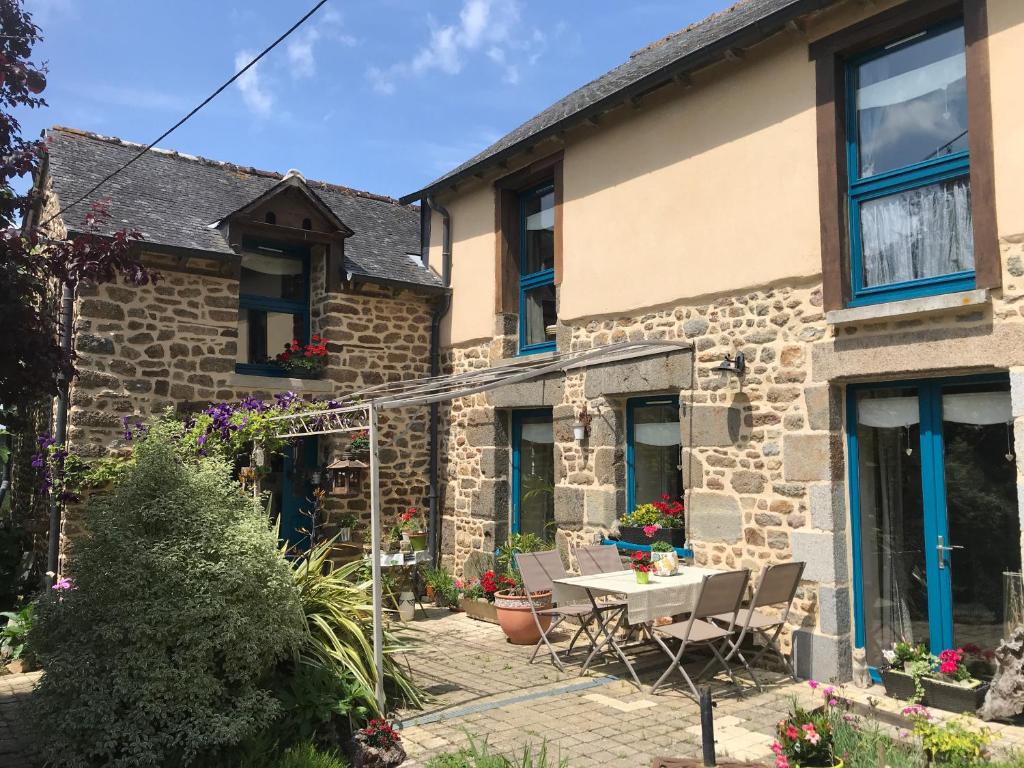 a stone house with a table and chairs outside at Chambre à la campagne in Québriac