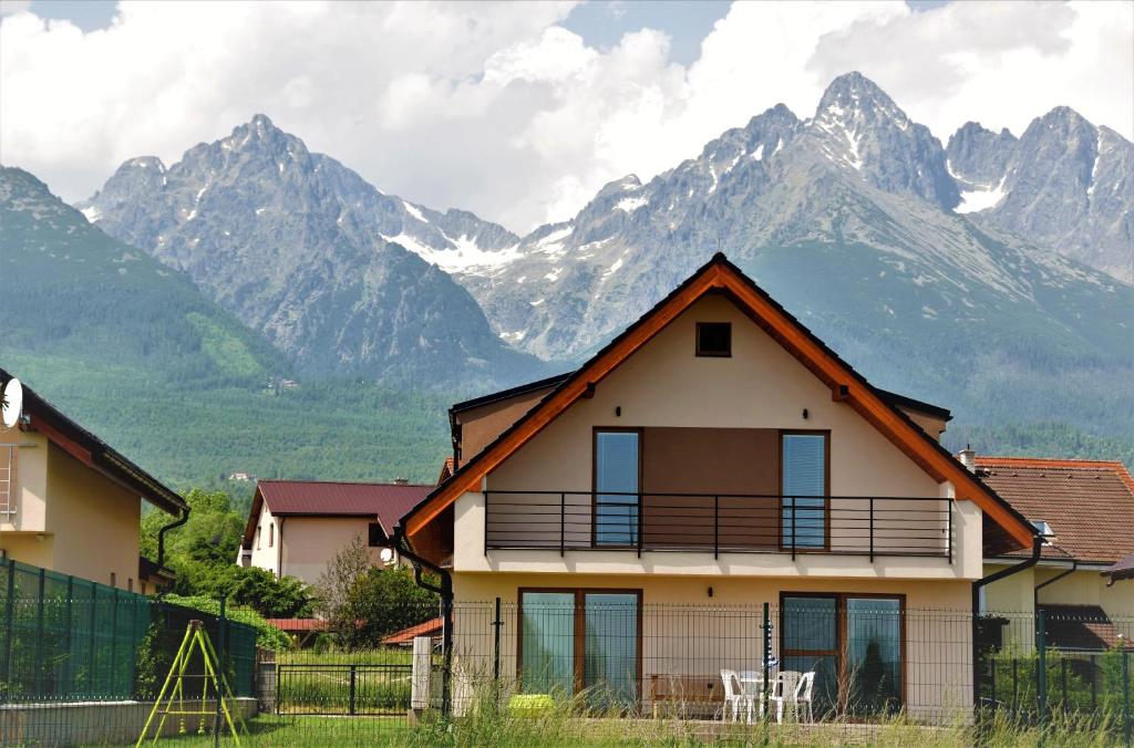 a house with mountains in the background at Tatras Apartments 622 in Nová Lesná
