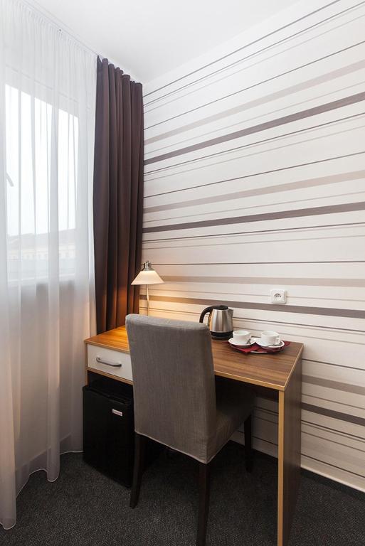a wooden desk with a chair next to a window at Arkada Hotel in Bučovice