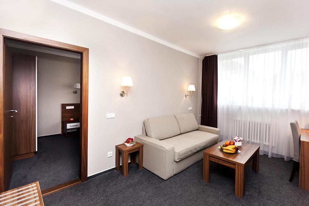 a living room with a couch and a table at Arkada Hotel in Bučovice