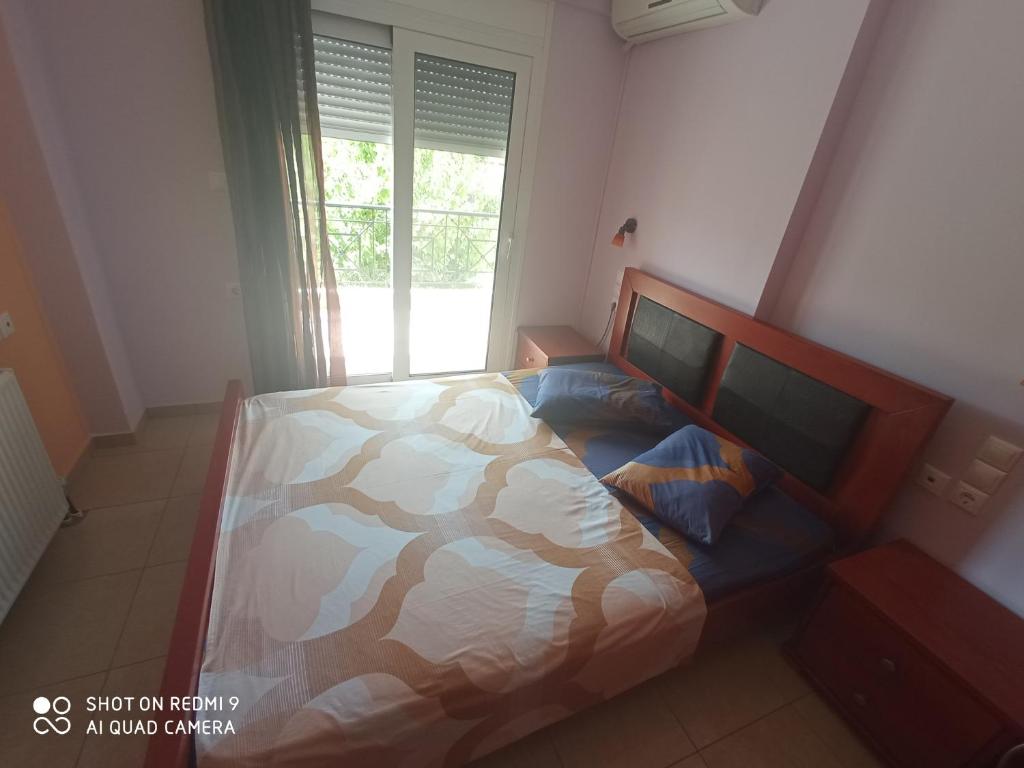 1 dormitorio con cama de camuflaje y ventana en Apostolia Lux Apartments, en Volos