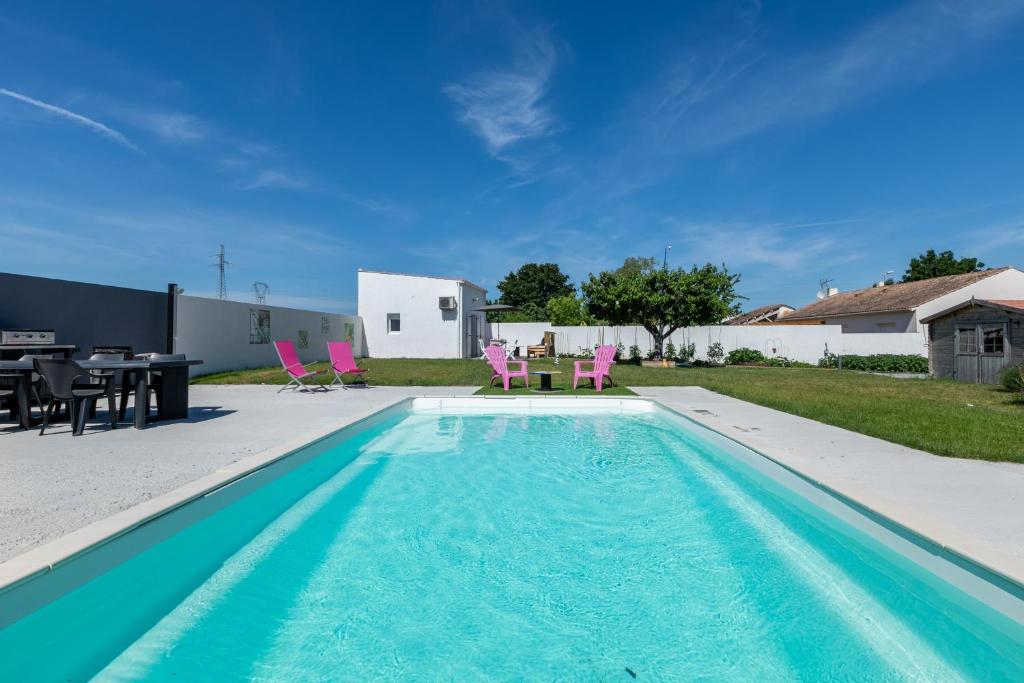 - une piscine avec une table et des chaises dans la cour dans l'établissement Cosy Corner, à Saint-Xandre