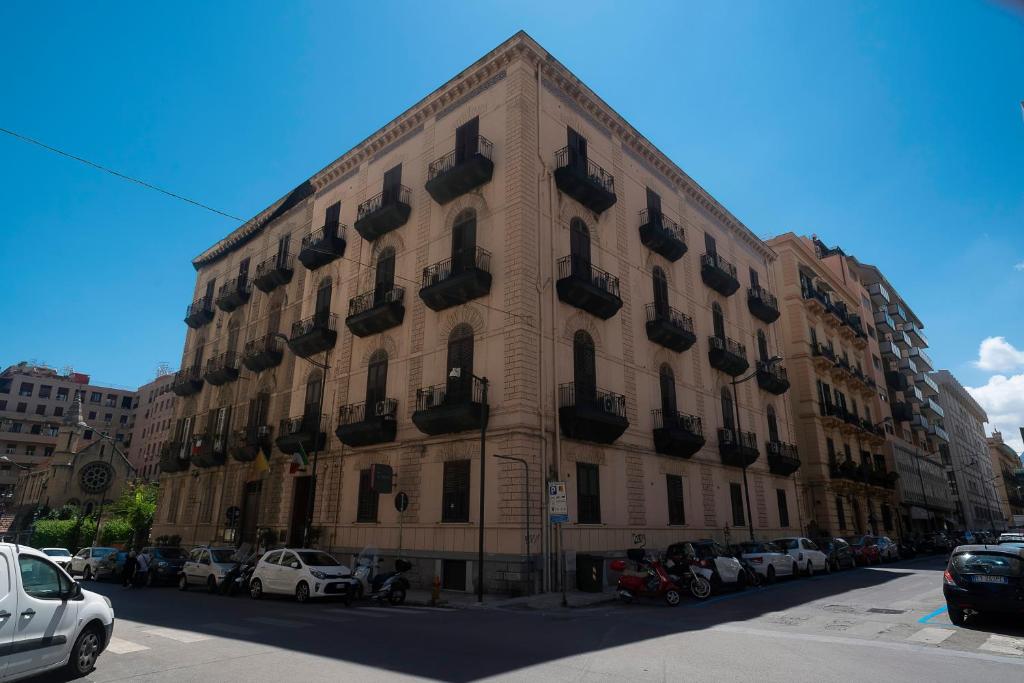 duży budynek z samochodami zaparkowanymi przed nim w obiekcie Hotel Tonic w mieście Palermo