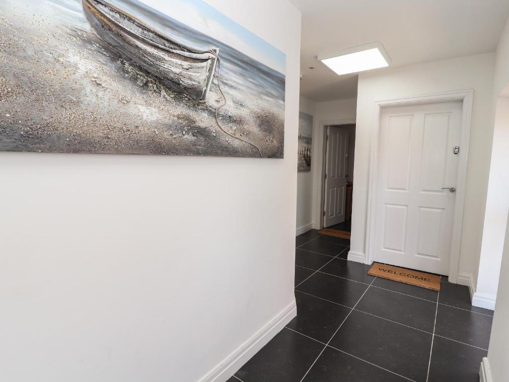 un couloir avec une peinture d'un bateau sur le mur dans l'établissement Flat 2, à Prestatyn