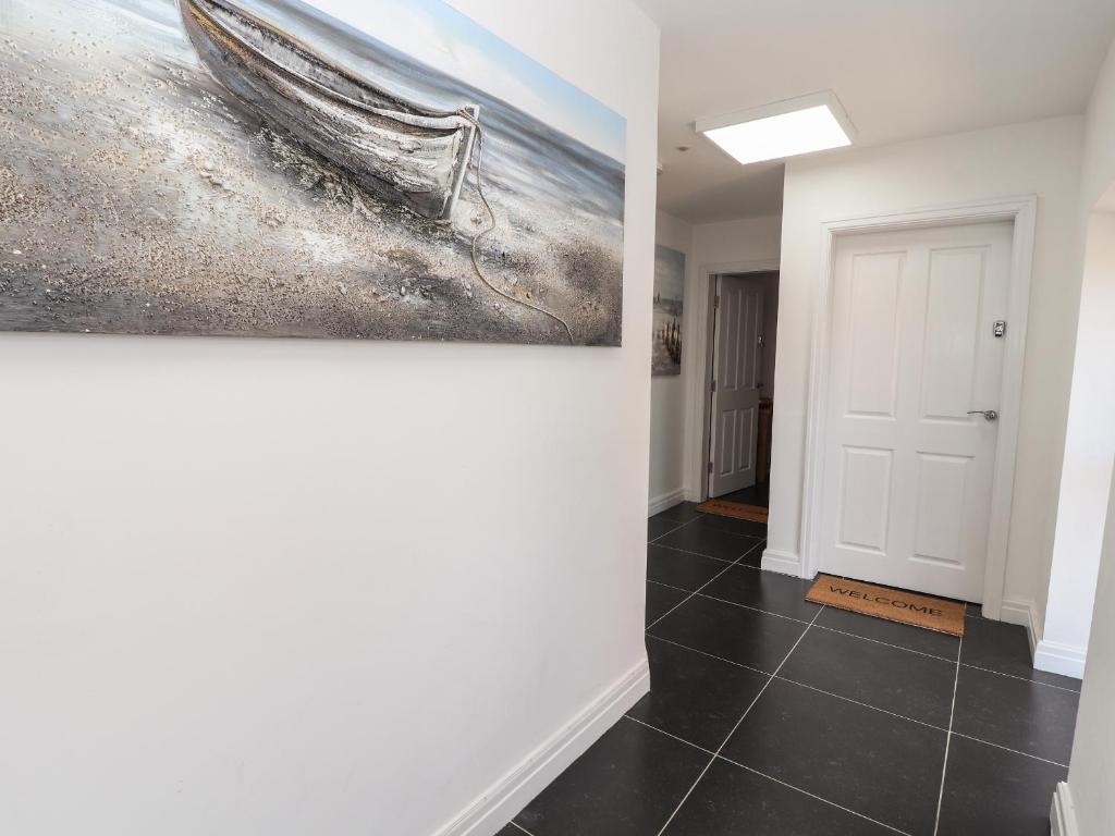 a hallway with a painting of a boat on the wall at Flat 2 in Prestatyn