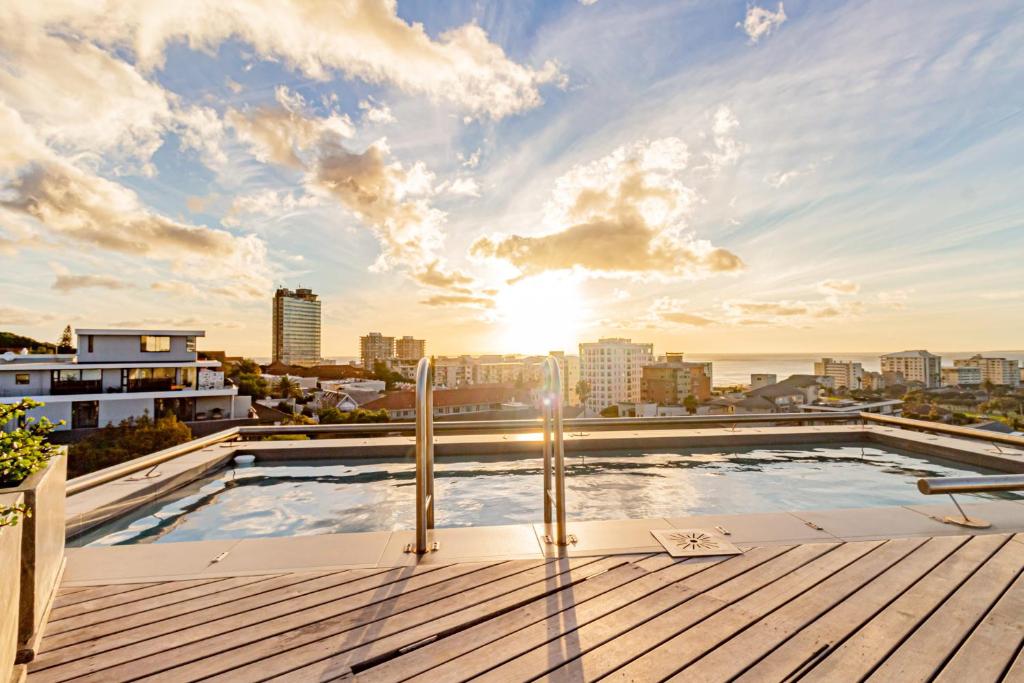 a rooftop swimming pool on top of a building with a city skyline at Scholtz Penthouse in Cape Town