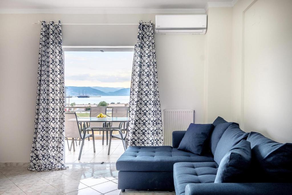 a living room with a blue couch in front of a window at Amazing View Family Penthouse in Nafplio