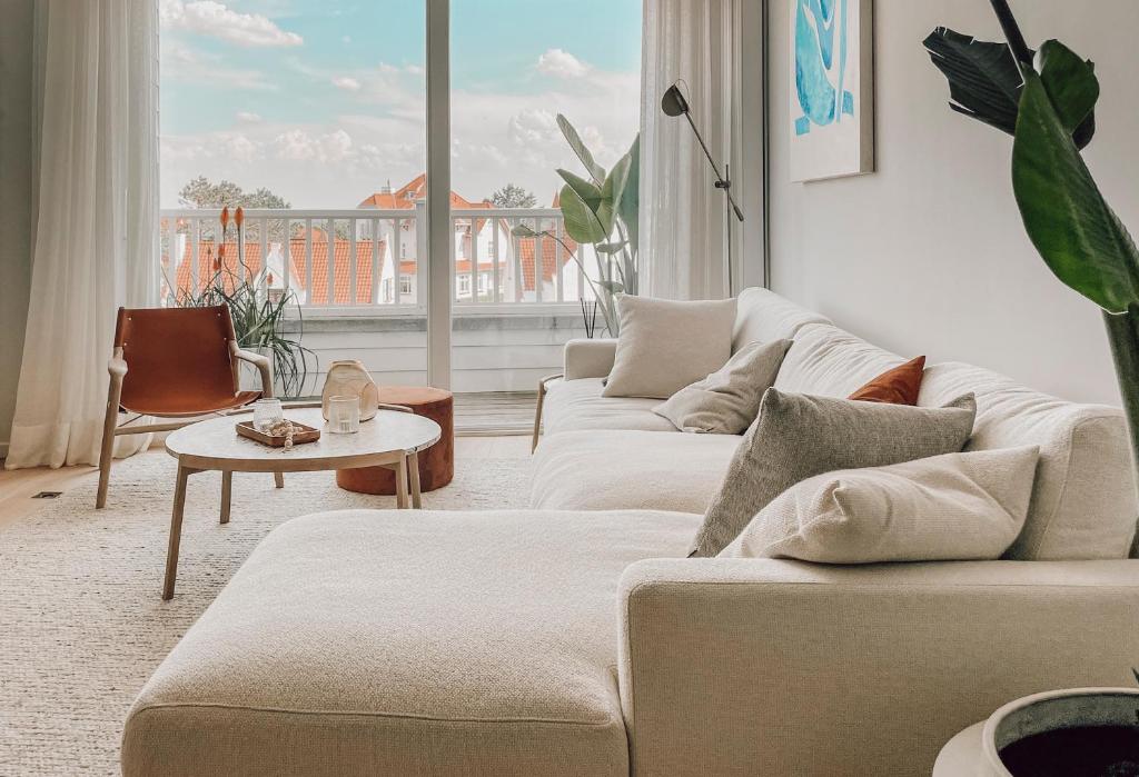 a living room with two couches and a table at ZETU The Dunes in Knokke-Heist