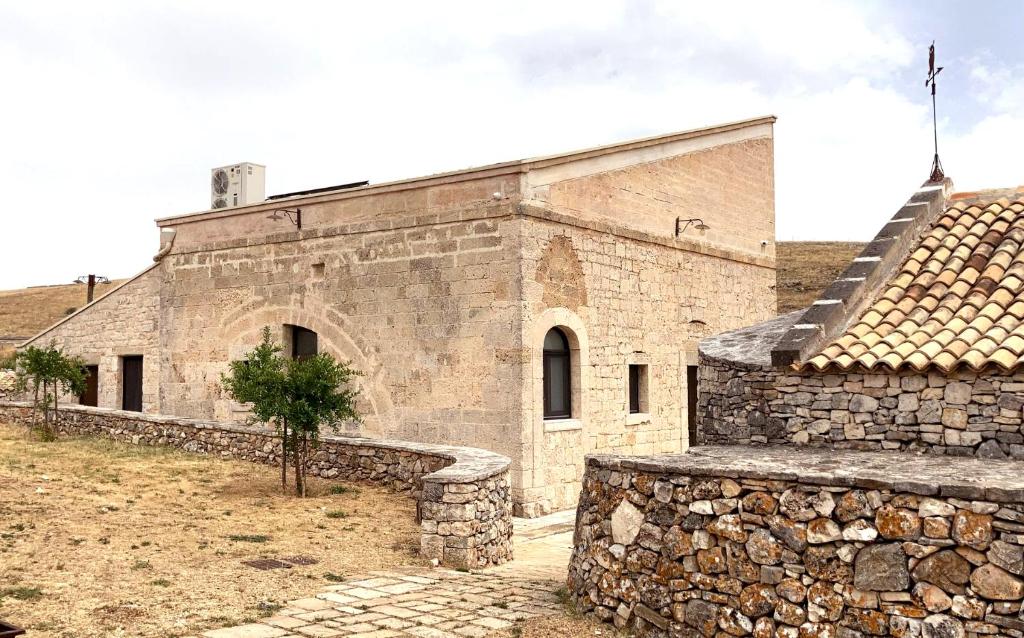 una antigua iglesia de piedra con una pared de piedra en asfodelo ristorante di campagna, en Altamura
