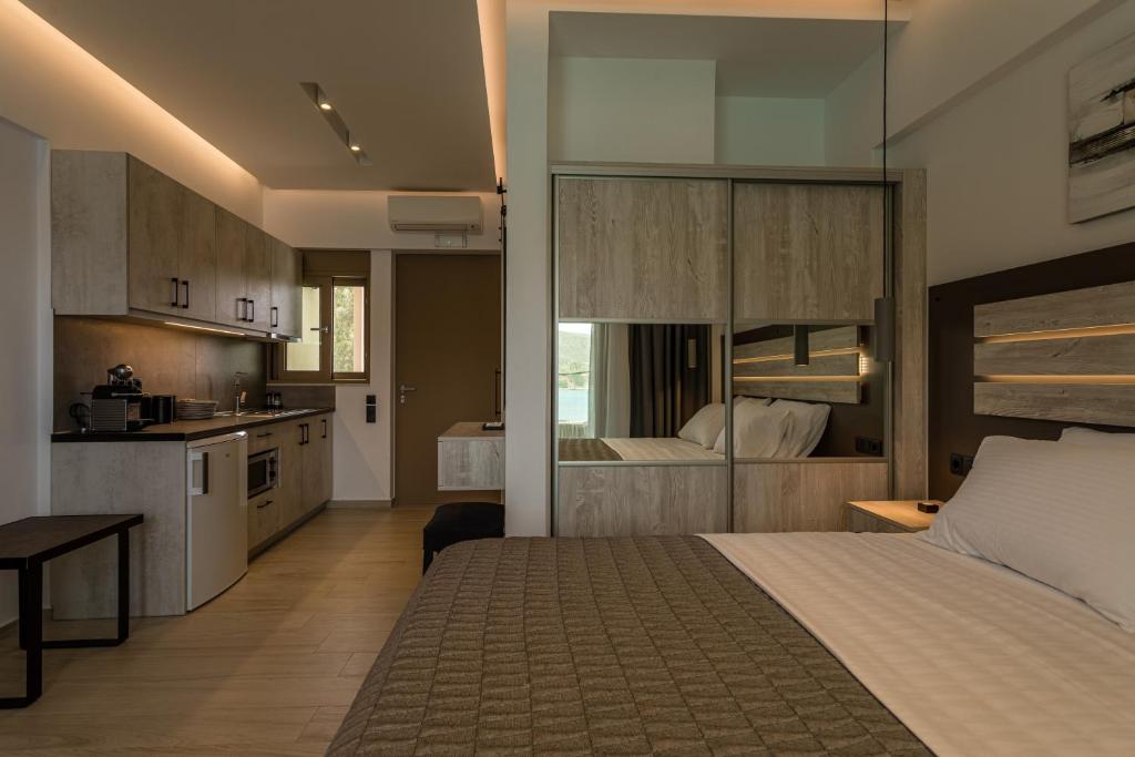 a bedroom with a large bed and a kitchen at Lighthouse Apartments in Stoupa