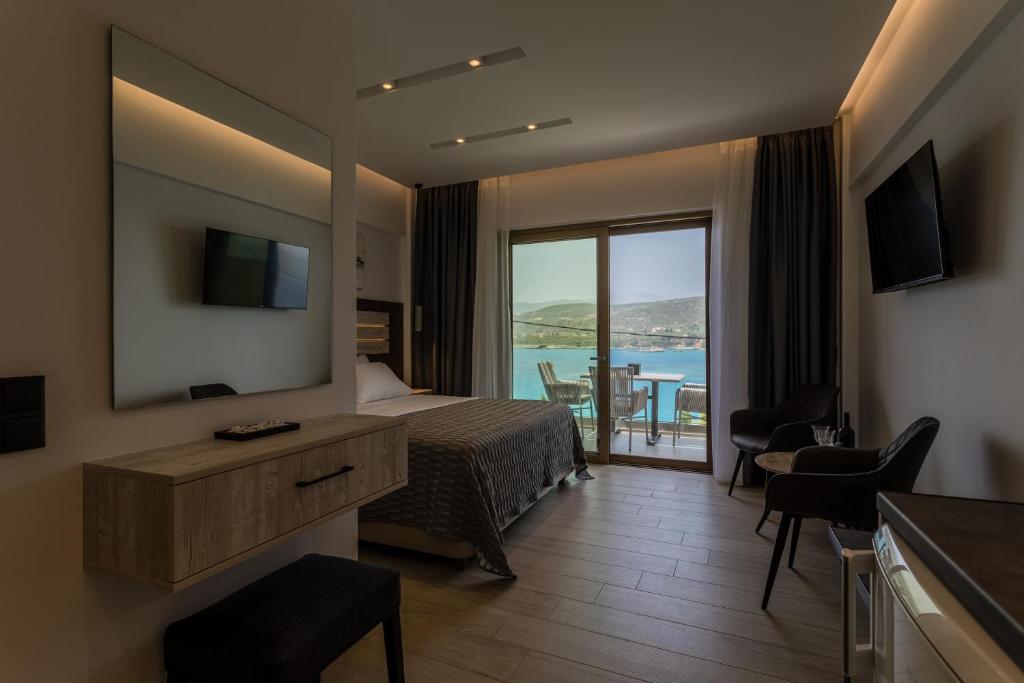 a hotel room with a bed and a view of the ocean at Lighthouse Apartments in Stoupa