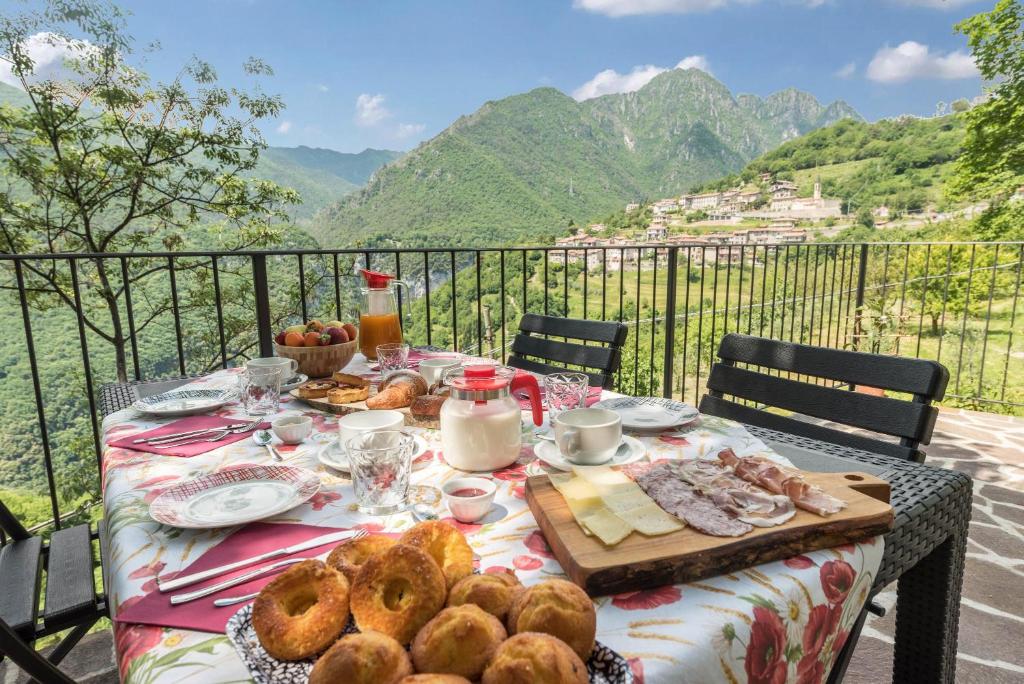 een tafel met eten erop met uitzicht op de bergen bij Nonno Bigi Papavero in Tremosine Sul Garda