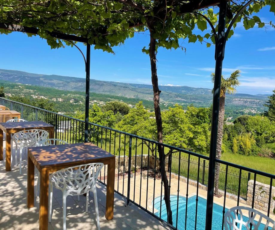 balcone con tavoli, sedie e vista di Domaine de la Pinède ad Aubenas