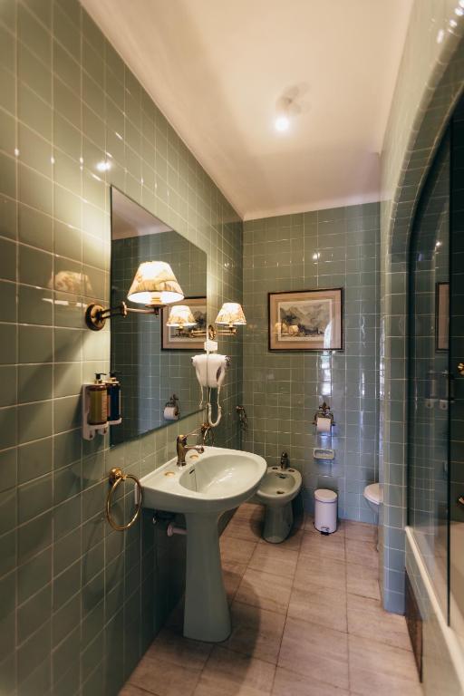 a bathroom with a sink and a toilet at Pergola Boutique Hotel in Cascais