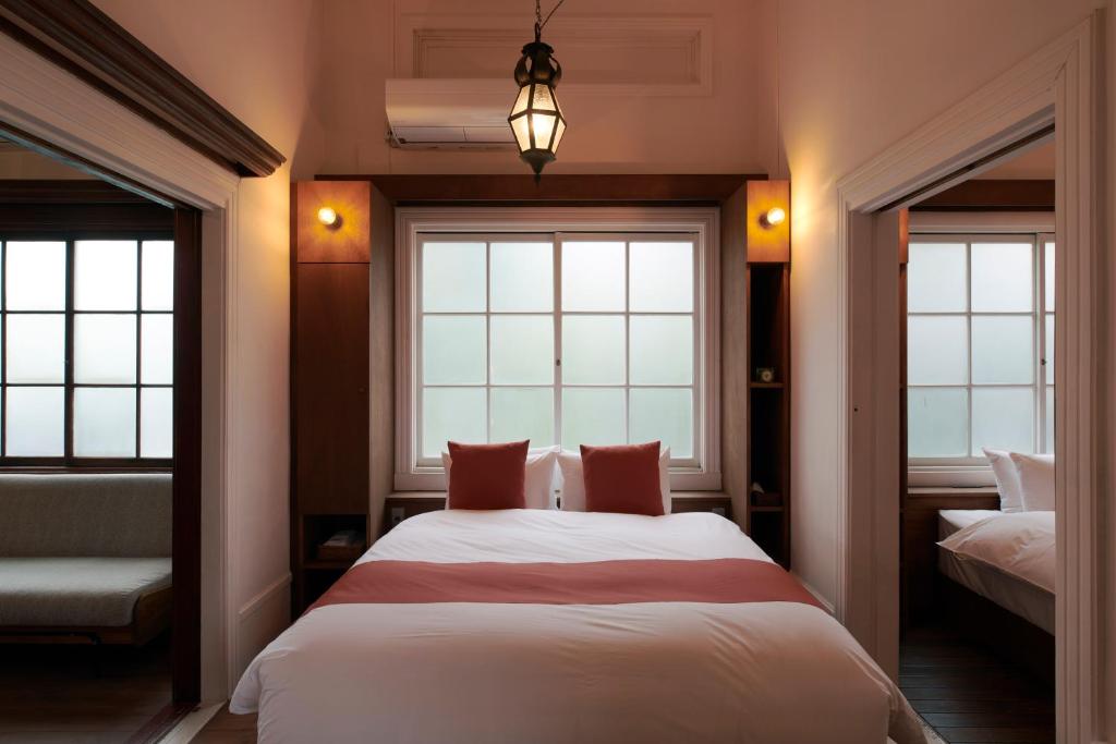 um quarto com uma cama e duas janelas em Shirafuji em Suzaka
