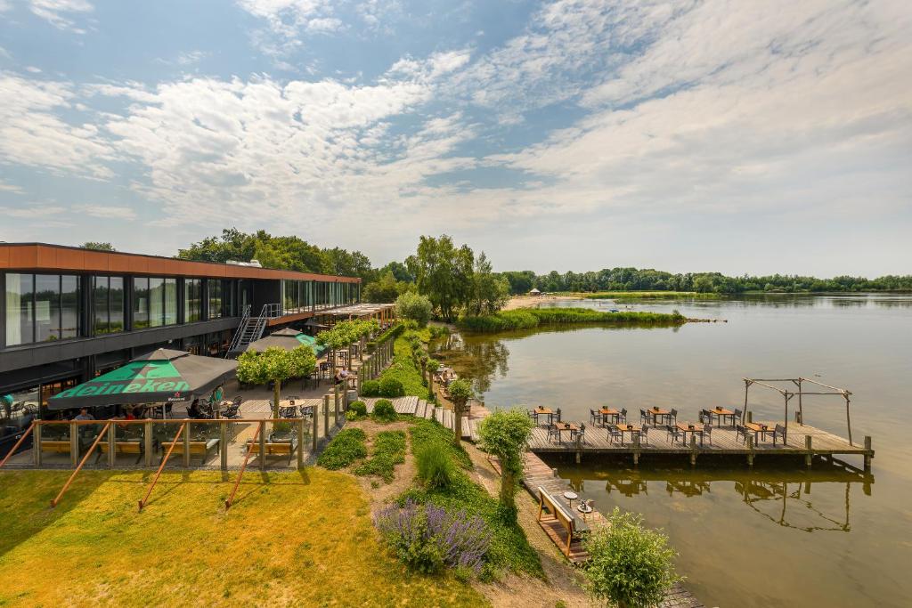 a resort with a dock next to a body of water at Postillion Amersfoort Veluwemeer in Putten