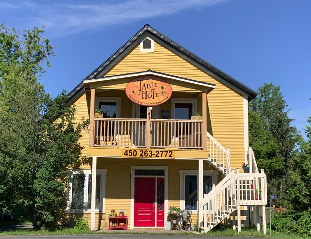 Una casa con un letrero que lee hace una cabaña en Auberge La Table d'Hôte, en West Brome