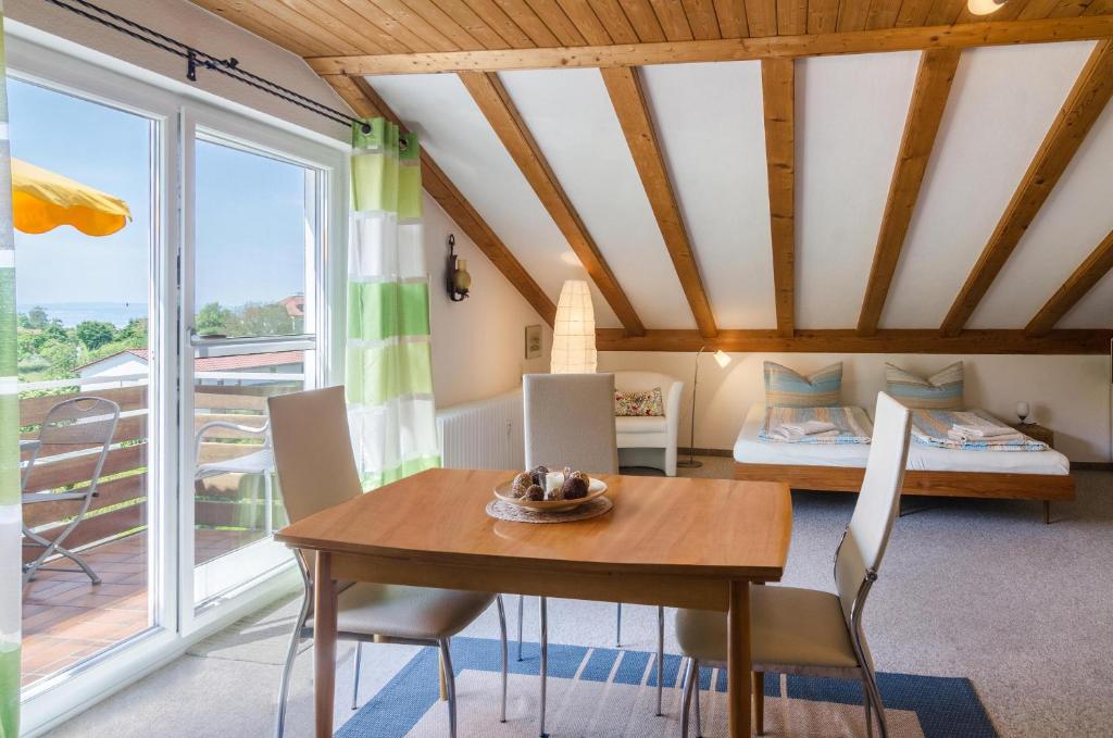 a room with a table and chairs and a bed at Ferienwohnung Säntisblick in Daisendorf