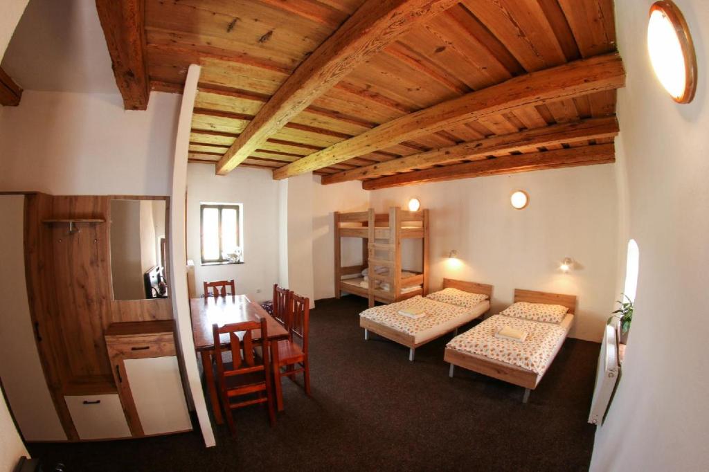 a room with two beds and a table and chairs at Apartmány Na Rynku Chvalšiny 18 in Český Krumlov