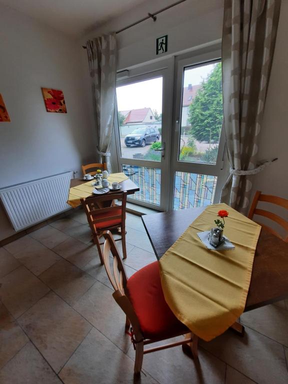 ein Wohnzimmer mit einem Tisch und Stühlen sowie einem Balkon in der Unterkunft Landpension Rödigsdorf in Rödigsdorf