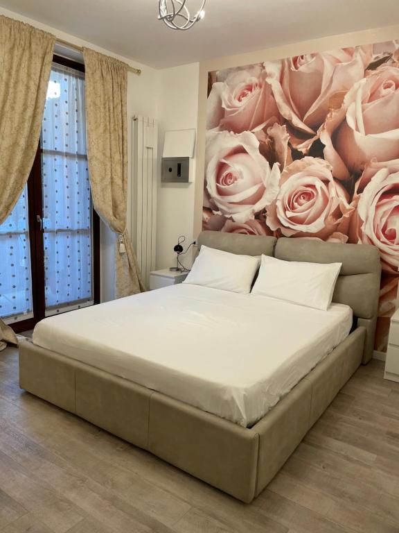 1 dormitorio con 1 cama con una pintura de rosas en casa vacanze esmeralda, en Zanica