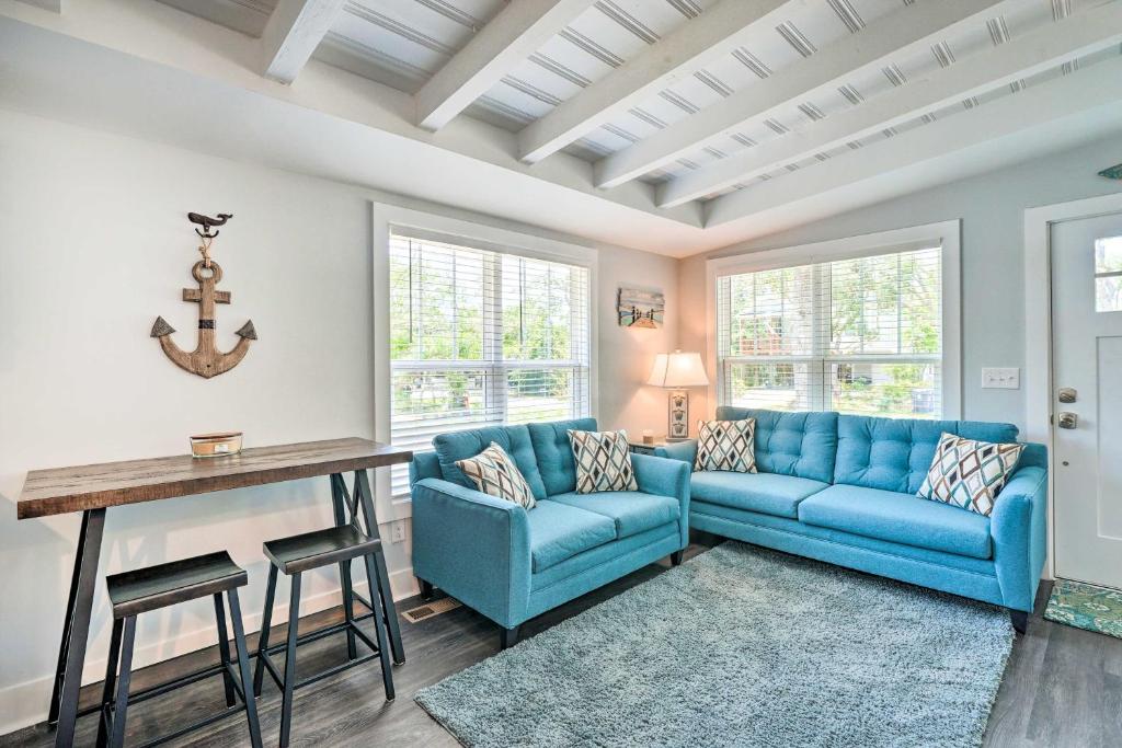 a living room with a blue couch and a table at Modern Oak Island Escape 1 Mile to Long Beach! in Oak Island