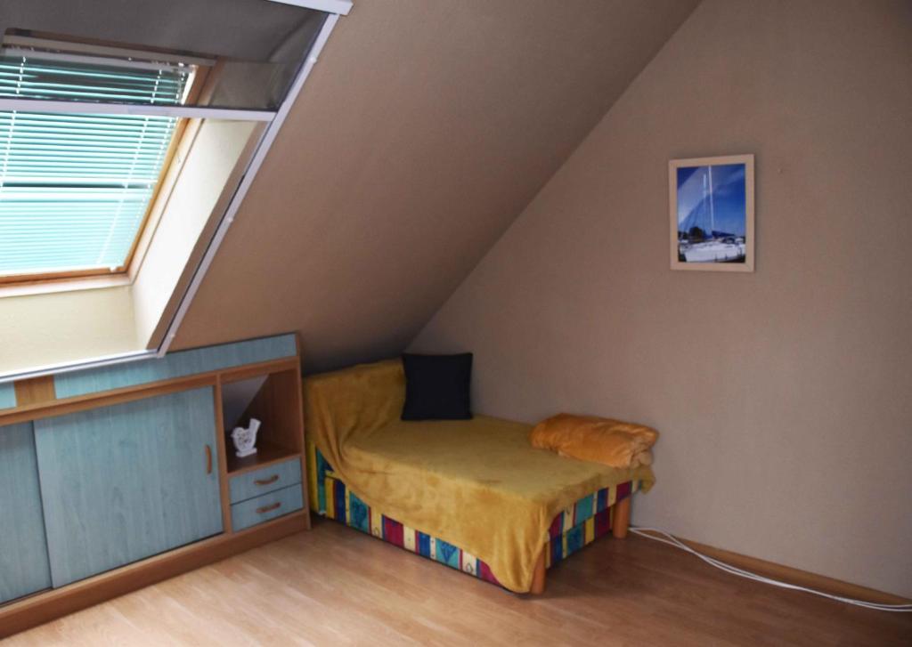 Dormitorio pequeño con cama en el ático en Pilikán Apartments - Park, Market, Vineyard & Sheep farm, en Cserszegtomaj