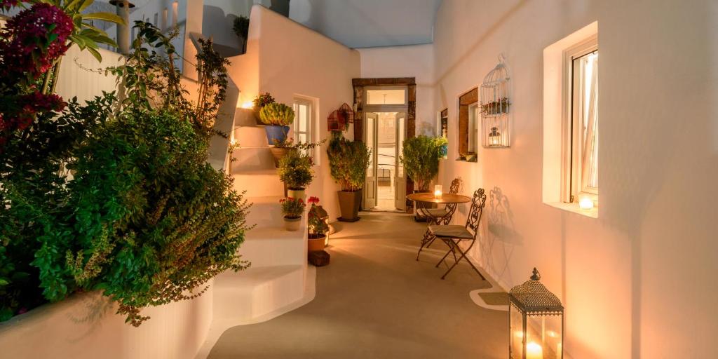 um corredor com vasos de plantas nas paredes em Betty's Home Santorini em Karterados