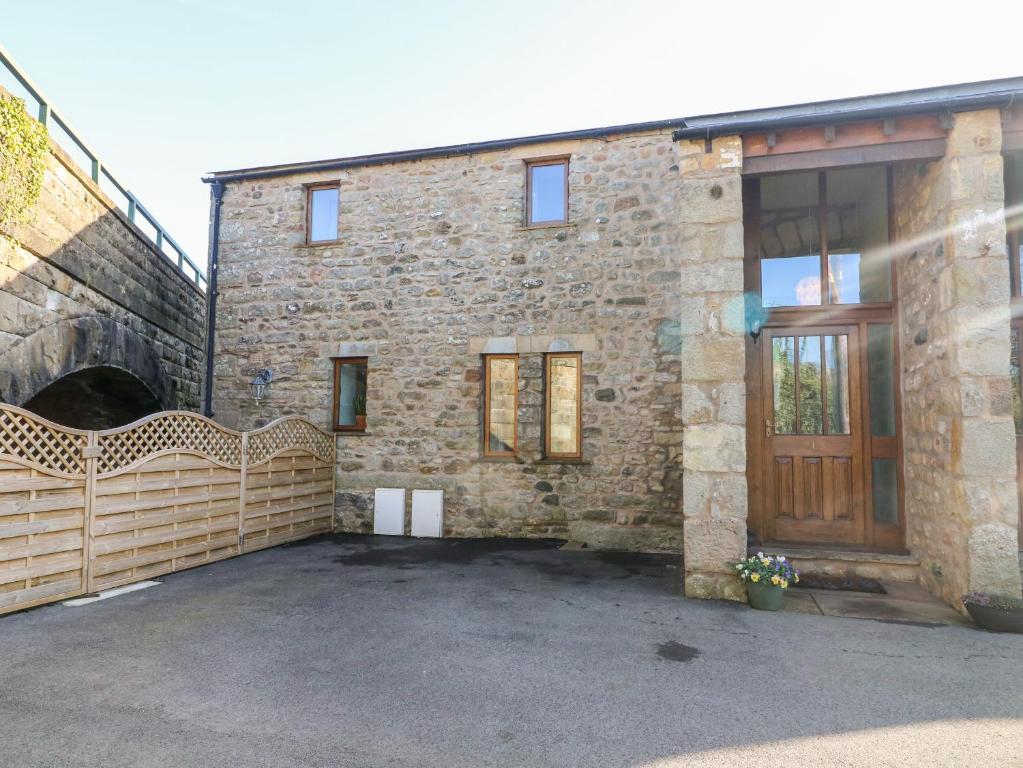 un edificio de ladrillo con una puerta y un garaje en 1 Netherbeck Barn en Carnforth