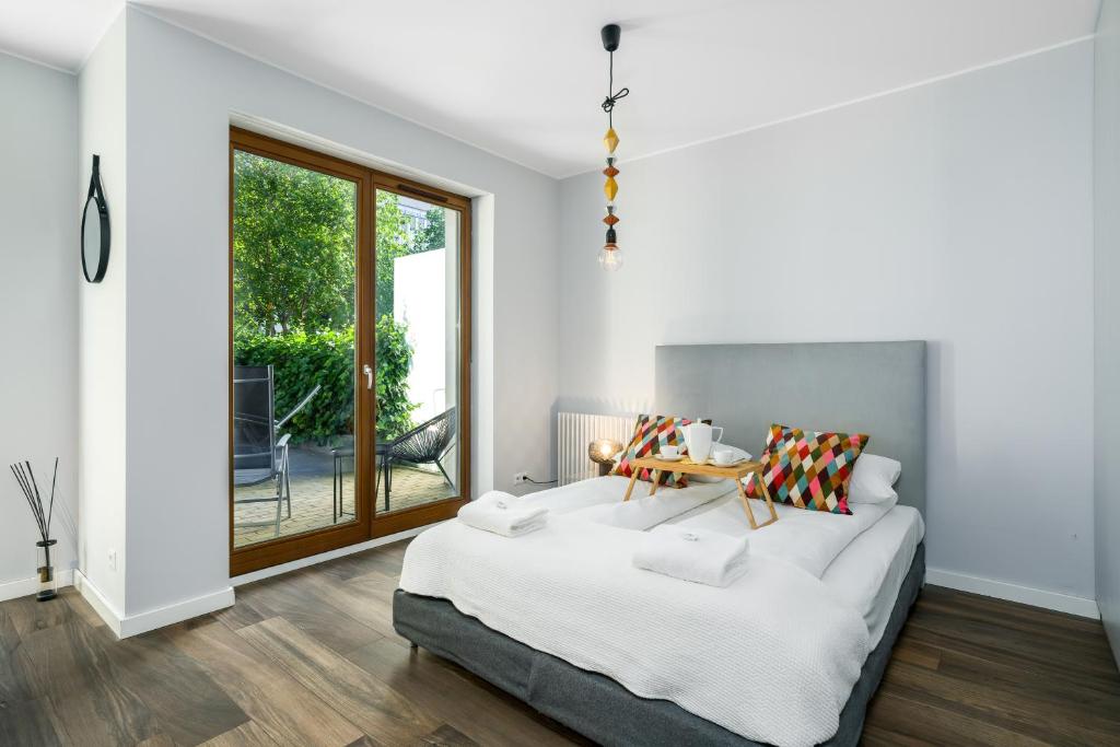 sypialnia z dużym łóżkiem i oknem w obiekcie Maraton Gardens Apartments by Renters w Poznaniu
