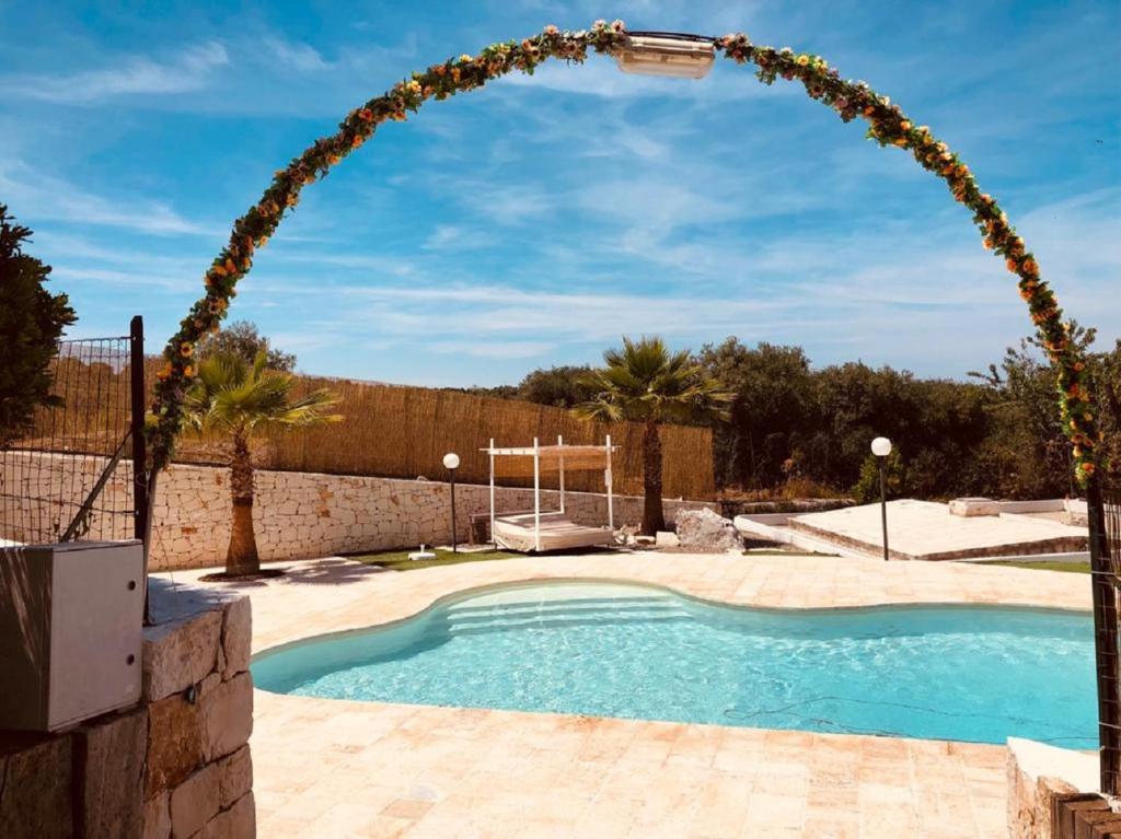 un arco sopra una piscina in un cortile di Villa Giuseppina a Monopoli