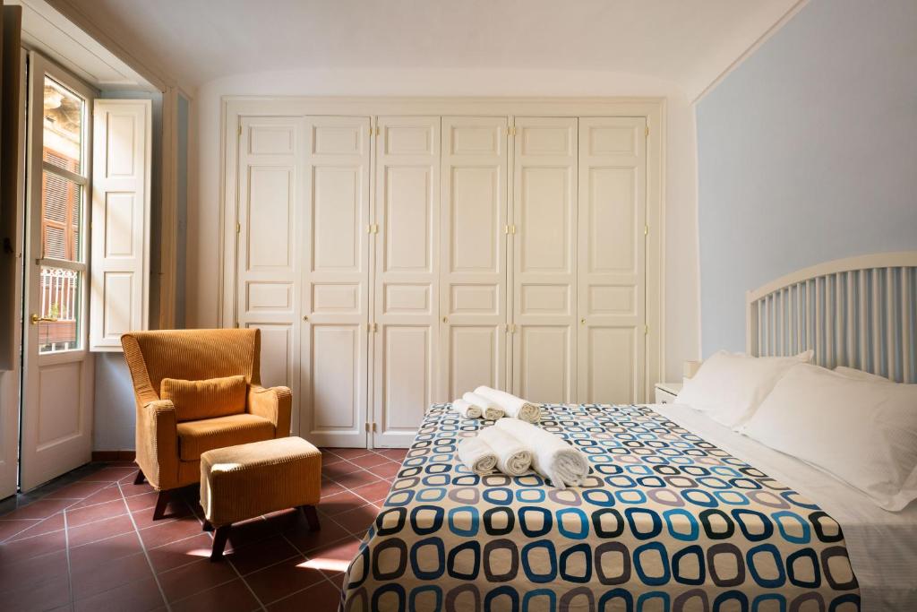 ein Schlafzimmer mit einem Bett mit einem ausgestopften Tier darauf in der Unterkunft I Tre Balconi di Via Roma Apartment in Syrakus