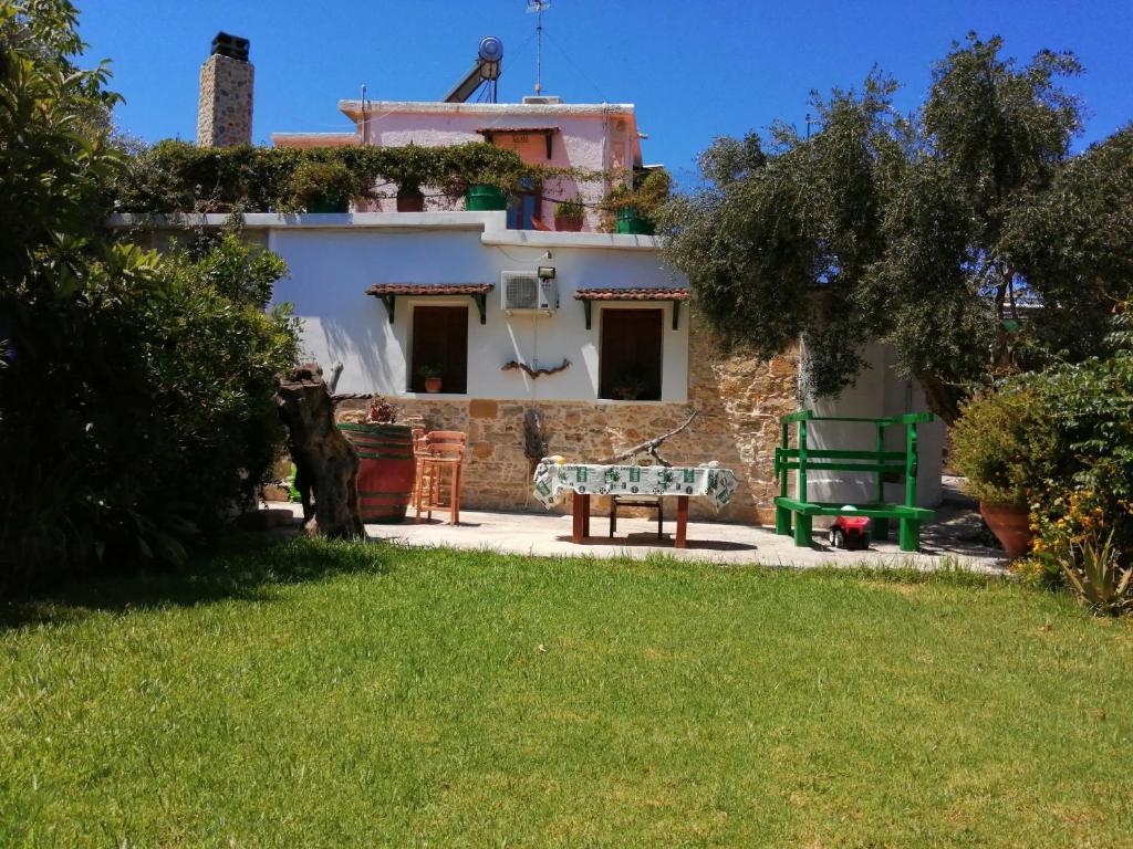 una casa con jardín y una mesa frente a ella en Sofiana Traditional Villa with swimming pool, en Dhrapaniás