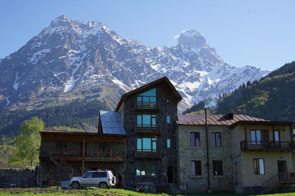 ein Haus mit einem Berg im Hintergrund in der Unterkunft Peak Mazeri Guest House in Mazeri